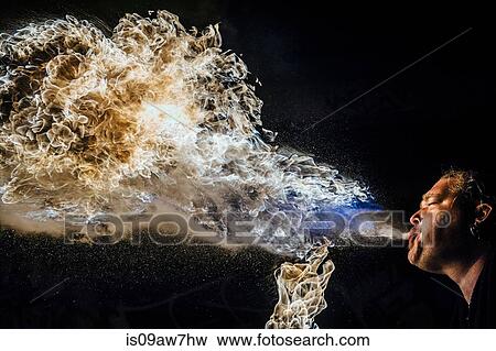Low angle view of man fire breathing View Large Photo Image Stock Photo - Low angle view of man fire breathing. Fotosearch