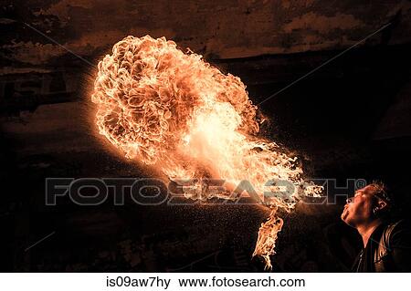 Low angle view of man fire breathing View Large Photo Image Stock Photo - Low angle view of man fire breathing. Fotosearch