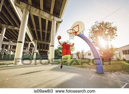 Low angle view of man on basketball court in mid air jumping for basketball hoop View Large Photo Image Stock Image - Low angle view of man on basketball court in mid air jumping for basketball hoop. Fotosearch