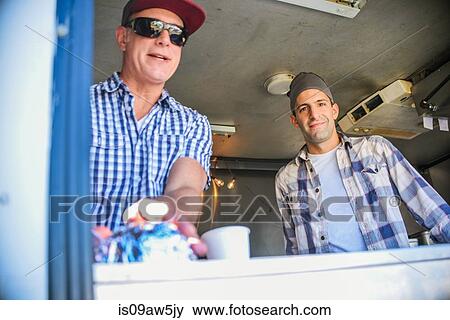 Low angle view of men in catering van looking through hatch at camera smiling View Large Photo Image Stock Photo - Low angle view of men in catering van looking through hatch at camera smiling. Fotosearch