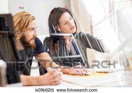 Male and female designer looking at computer in creative studio View Large Photo Image Stock Photography - Male and female designer looking at computer in creative studio. Fotosearch