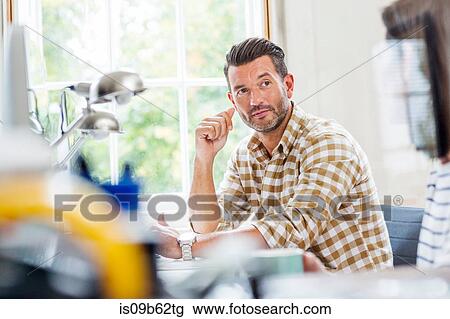 Stock Image - Male and female designers having meeting in creative studio. Fotosearch