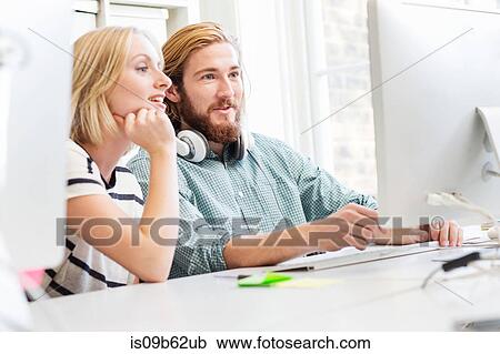 Male and female designers looking at desktop computer in creative studio View Large Photo Image Stock Image - Male and female designers looking at desktop computer in creative studio. Fotosearch