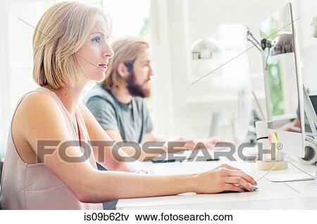 Male and female designers using desktop computers in creative studio View Large Photo Image Stock Photo - Male and female designers using desktop computers in creative studio. Fotosearch