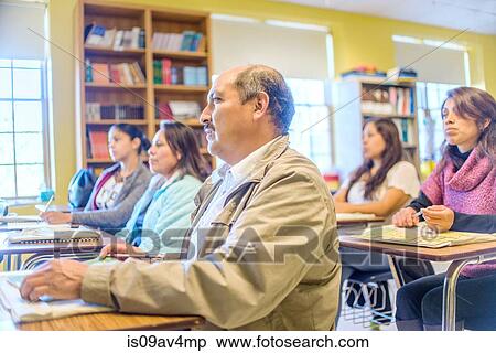 Stock Photography - Male and female mature students listening from class desks. Fotosearch