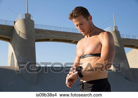Male athlete checking smartwatch, Van Nuys, California, USA View Large Photo Image Picture - Male athlete checking smartwatch, Van Nuys, California, USA. Fotosearch