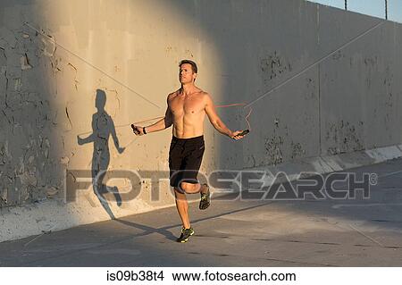 Male athlete skipping with resistance band View Large Photo Image Picture - Male athlete skipping with resistance band. Fotosearch