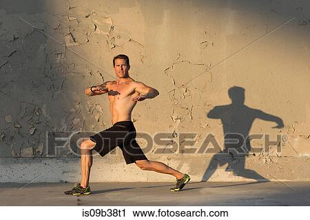 Male athlete stretching in front of concrete wall View Large Photo Image Stock Image - Male athlete stretching in front of concrete wall. Fotosearch