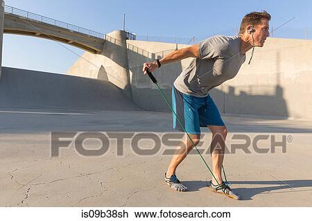 Male athlete stretching with resistance band, Van Nuys, California, USA View Large Photo Image Stock Image - Male athlete stretching with resistance band, Van Nuys, California, USA. Fotosearch