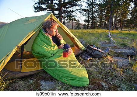 Male camper sitting up in sleeping bag watching sunset on Midnight Ridge, Colville National Forest, Washington State, USA View Large Photo Image Picture - Male camper sitting up in sleeping bag watching sunset on Midnight Ridge, Colville National Forest, Washington State, USA. Fotosearch