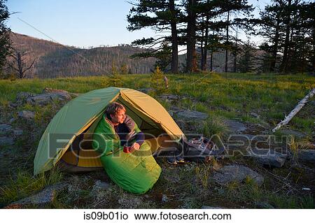Male camper sitting up in sleeping bag watching sunset on Midnight Ridge, Colville National Forest, Washington State, USA View Large Photo Image Picture - Male camper sitting up in sleeping bag watching sunset on Midnight Ridge, Colville National Forest, Washington State, USA. Fotosearch