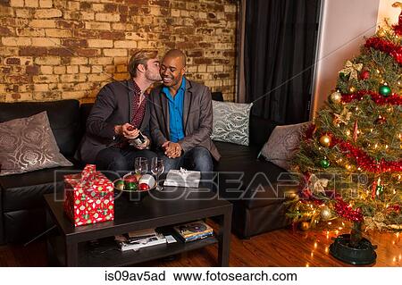 Male couple celebrating Christmas, young man giving partner a kiss View Large Photo Image Stock Image - Male couple celebrating Christmas, young man giving partner a kiss. Fotosearch