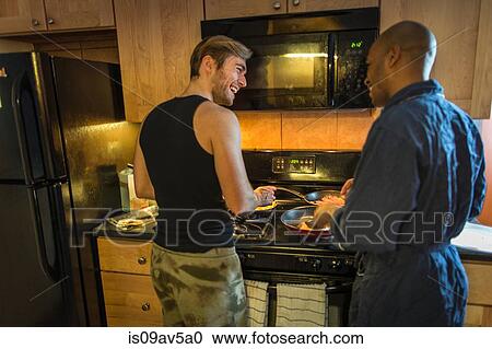 Stock Image - Male couple in kitchen, making breakfast. Fotosearch