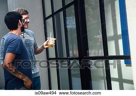 Male couple looking at city shop window View Large Photo Image Picture - Male couple looking at city shop window. Fotosearch
