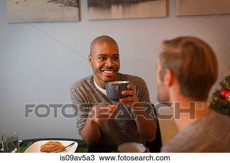 Male couple sitting at table, having breakfast together View Large Photo Image Stock Image - Male couple sitting at table, having breakfast together. Fotosearch