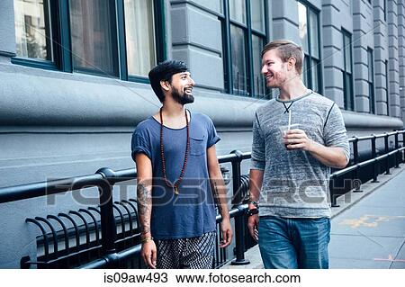 Male couple strolling and chatting on city street View Large Photo Image Stock Image - Male couple strolling and chatting on city street. Fotosearch