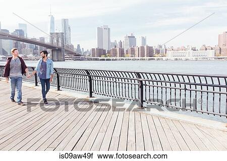 Male couple strolling on riverside by Brooklyn Bridge, New York, USA View Large Photo Image Stock Image - Male couple strolling on riverside by Brooklyn Bridge, New York, USA. Fotosearch