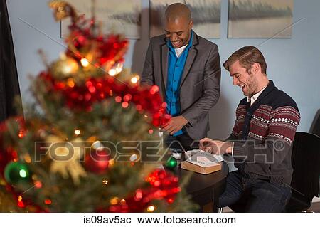 Male couple wrapping Christmas gifts View Large Photo Image Stock Image - Male couple wrapping Christmas gifts. Fotosearch