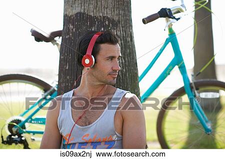 Male cyclist sitting listening to headphone music at Venice Beach, Los Angeles, California, USA View Large Photo Image Stock Image - Male cyclist sitting listening to headphone music at Venice Beach, Los Angeles, California, USA. Fotosearch