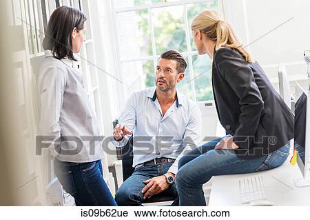Male designer explaining idea to female colleagues in creative studio meeting View Large Photo Image Stock Image - Male designer explaining idea to female colleagues in creative studio meeting. Fotosearch