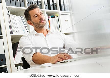 Picture - Male designer typing on computer keyboard at desk in creative studio. Fotosearch