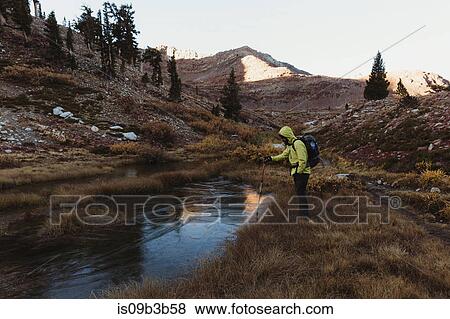 Stock Photo - Male hiker looking down at lake, Mineral King, Sequoia National Park, California, USA. Fotosearch