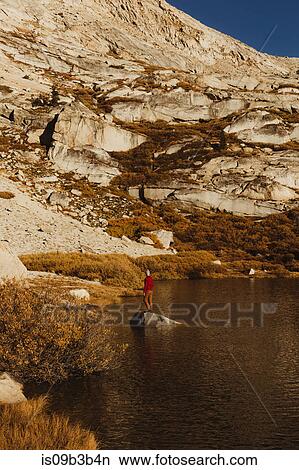 Picture - Male hiker looking out from lake rock, Mineral King, Sequoia National Park, California, USA. Fotosearch