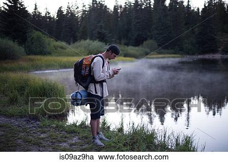 Male hiker reading smartphone text by misty lake, Mount Hood National Forest, Oregon, USA View Large Photo Image Stock Image - Male hiker reading smartphone text by misty lake, Mount Hood National Forest, Oregon, USA. Fotosearch
