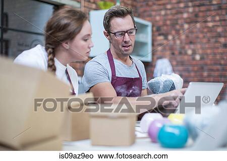 Male potter explaining packing of online pot in workshop View Large Photo Image Picture - Male potter explaining packing of online pot in workshop. Fotosearch