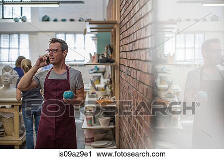 Male potter talking on smartphone in workshop View Large Photo Image Stock Image - Male potter talking on smartphone in workshop. Fotosearch