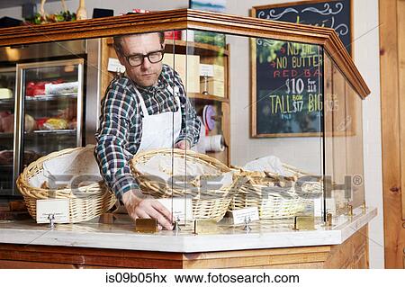 Male worker in bakery, adjusting price ticket in cabinet View Large Photo Image Stock Photo - Male worker in bakery, adjusting price ticket in cabinet. Fotosearch