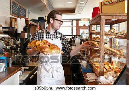 Male worker in bakery, putting fresh pastries into display cabinet View Large Photo Image Stock Photograph - Male worker in bakery, putting fresh pastries into display cabinet. Fotosearch