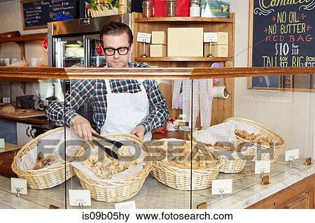 Male worker in bakery, taking fresh goods from basket View Large Photo Image Stock Photo - Male worker in bakery, taking fresh goods from basket. Fotosearch