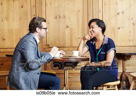 Man and woman sitting in cafe drinking coffee View Large Photo Image Stock Image - Man and woman sitting in cafe drinking coffee. Fotosearch