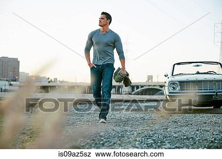 Stock Photo - Man by convertible car looking away, Los Angeles, California, USA. Fotosearch