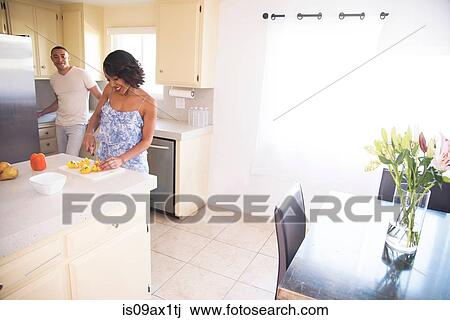 Man chatting with woman cutting fruit in kitchen View Large Photo Image Stock Image - Man chatting with woman cutting fruit in kitchen. Fotosearch