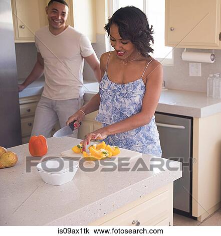 Man chatting with woman cutting fruit in kitchen View Large Photo Image Stock Image - Man chatting with woman cutting fruit in kitchen. Fotosearch