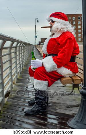 Man dressed in Santa suit, sitting on bench, smoking cigar, holding bottle of beer View Large Photo Image Stock Image - Man dressed in Santa suit, sitting on bench, smoking cigar, holding bottle of beer. Fotosearch