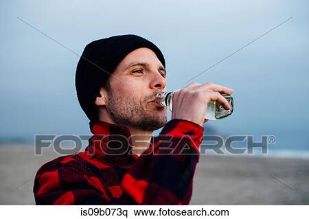 Man drinking bottled water on beach, Morro Bay, California, USA View Large Photo Image Stock Photography - Man drinking bottled water on beach, Morro Bay, California, USA. Fotosearch