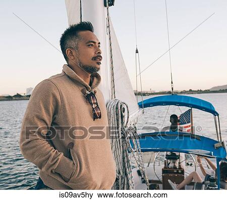 Stock Photo - Man enjoying view on sailboat, San Diego Bay, California, USA. Fotosearch