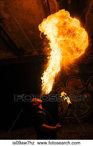 Man fire breathing in urban area View Large Photo Image Stock Photo - Man fire breathing in urban area. Fotosearch