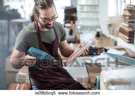 Man heating up plastic wrap on wooden spindle in factory View Large Photo Image Stock Photography - Man heating up plastic wrap on wooden spindle in factory. Fotosearch