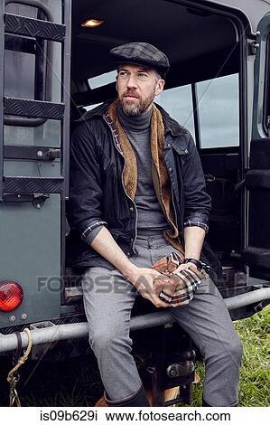 Man in outdoor clothes looking out from back door of off road vehicle View Large Photo Image Stock Image - Man in outdoor clothes looking out from back door of off road vehicle. Fotosearch