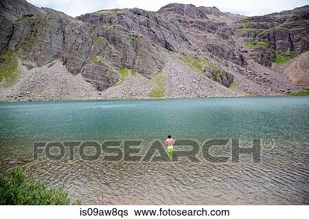 Stock Photograph - Man in water, Cathedral Lake, Aspen, Colorado. Fotosearch
