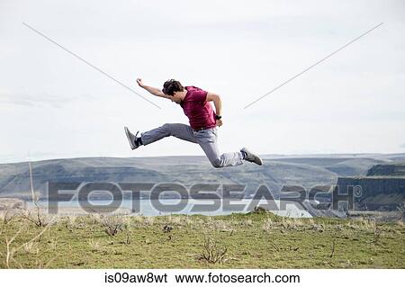 Man jumping, in mid air, on mountain top, Colombia River Gorge, Washington, USA View Large Photo Image Stock Photograph - Man jumping, in mid air, on mountain top, Colombia River Gorge, Washington, USA. Fotosearch