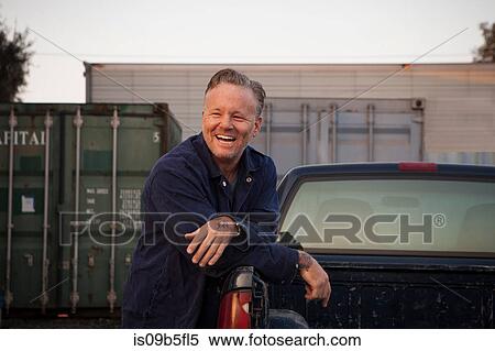 Man leaning against truck smiling View Large Photo Image Stock Photography - Man leaning against truck smiling. Fotosearch