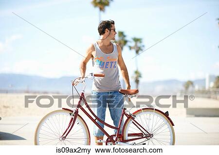 Man looking back whilst cycling at Venice Beach, Los Angeles, California, USA View Large Photo Image Stock Photo - Man looking back whilst cycling at Venice Beach, Los Angeles, California, USA. Fotosearch