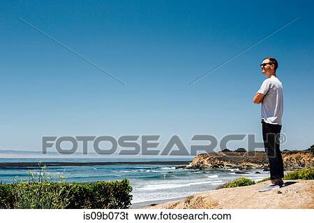 Man looking out over coast and sea, Cambria, California, USA View Large Photo Image Stock Photograph - Man looking out over coast and sea, Cambria, California, USA. Fotosearch