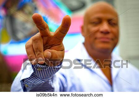 Man making peace sign hand gesture View Large Photo Image Picture - Man making peace sign hand gesture. Fotosearch
