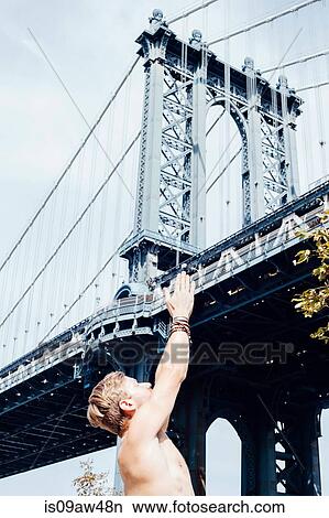 Man meditating with hands raised together in front of Manhattan Bridge, New York, USA View Large Photo Image Picture - Man meditating with hands raised together in front of Manhattan Bridge, New York, USA. Fotosearch
